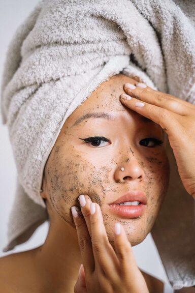 close up of young woman using exfoliating scrub on her face. best at home facial kit. Self care sunday. diy face mask. diy facial at home. at home facial steps. at home facial steamer. Best facial for glowing skin. how to get radiant skin.
