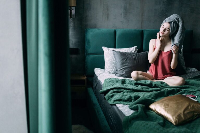 young woman relaxing in bed after her shower. What is an everything shower meaning everything shower. Everything shower list. everything shower routine. everything shower meaning. luxury shower. luxury shower routine.