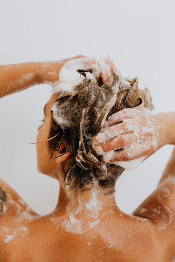 close up of woman shampooing her hair. What is an everything shower meaning everything shower. Everything shower list. everything shower routine. everything shower meaning. luxury shower. luxury shower routine.