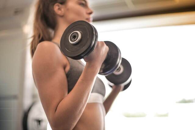 close up of woman lifting weights. weekend reset. weekend reset routine. wellness retreat. Bedroom retreat ideas. wellness retreat. home retreat ideas. Refreshed. self care weekend. self care weekend ideas. how to have a self care weekend.