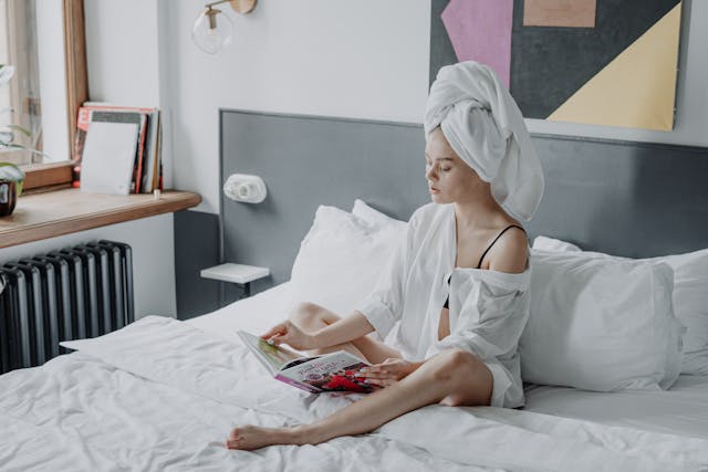 young woman relaxing in bed after washing her hair. What is an everything shower meaning everything shower. Everything shower list. everything shower routine. everything shower meaning. luxury shower. luxury shower routine.