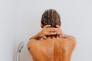 the back of a woman in the shower. Hangover breakfast ideas. hangover skin. how to fix a hangover quick. how to treat dehydrated skin. how to fix dehydrated skin. tired when hungover. re energize.