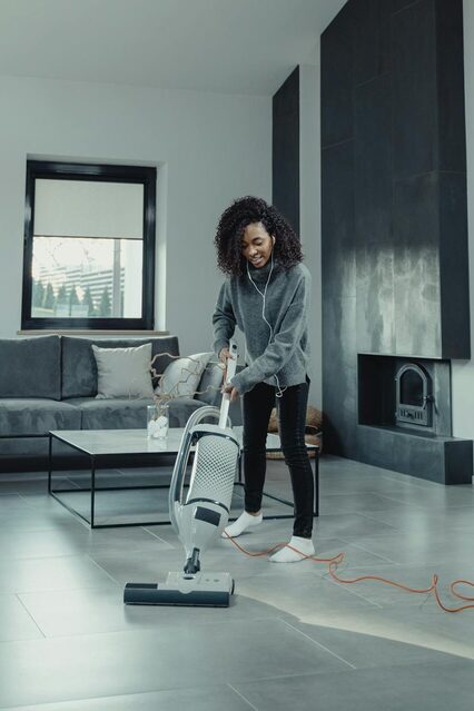 beautiful young woman vacuuming. Morning routine ideas. morning routine checklist. how to create a morning routine. how to start a morning routine. what is the best morning routine.