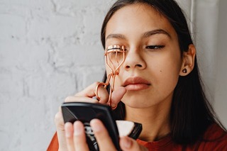 close up of young woman using an eyelash curler. how to look put together. how to always look put together. how to look put together every day. how to look put together all the time. how to look put together with minimal effort. that girl. How to glow up overnight.