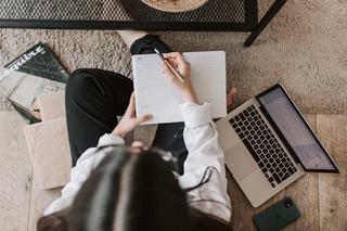 picture from above of a woman writing noted and using her laptop. how to look put together. how to always look put together. how to look put together every day. how to look put together all the time. how to look put together with minimal effort. that girl. How to glow up overnight.