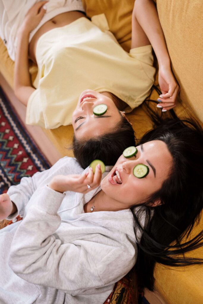 2 friends relaxing with cucumber slices on their eyes. galentines dinner ideas. February 13th. galentines day ideas. when is galentines day. girls night cocktails. girls night dinner ideas. girls night snack ideas. girls night in ideas.what to do for girls night. what to do on a girls night. Girl dinner.