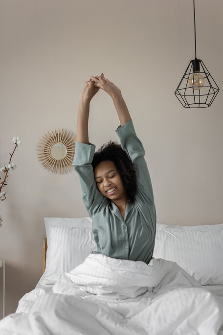 woman waking up and stretching in bed. quick morning workout,
morning home workout.